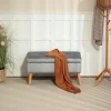Banquette coffre design scandinave piètement effilé bois assise effet capitonné velours gris