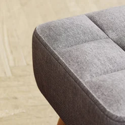 Pouf repose-pieds style nordique piètement bois incliné tissu assise effet capitonné gris